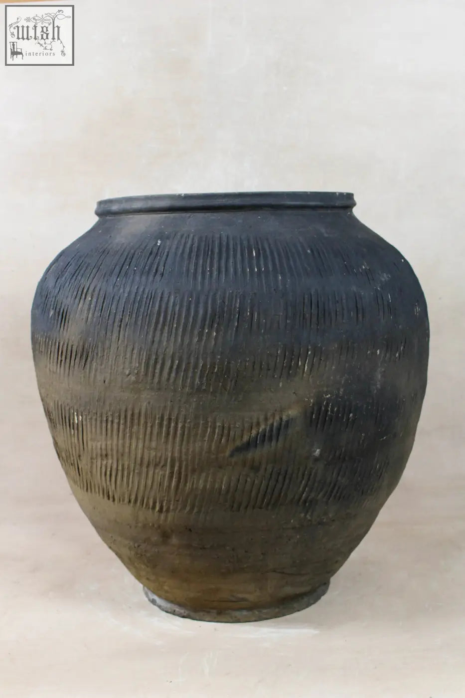 Vintage textured grey ceramic pot with horizontal ridges and a slightly worn dark surface for decor use