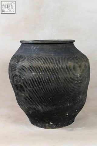Vintage textured grey ceramic jar with rounded body and ribbed surface showing aged patina finish