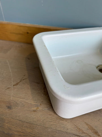 White ceramic vintage twyfords rectangular sink with rounded edges and central drain hole for utility or lab use