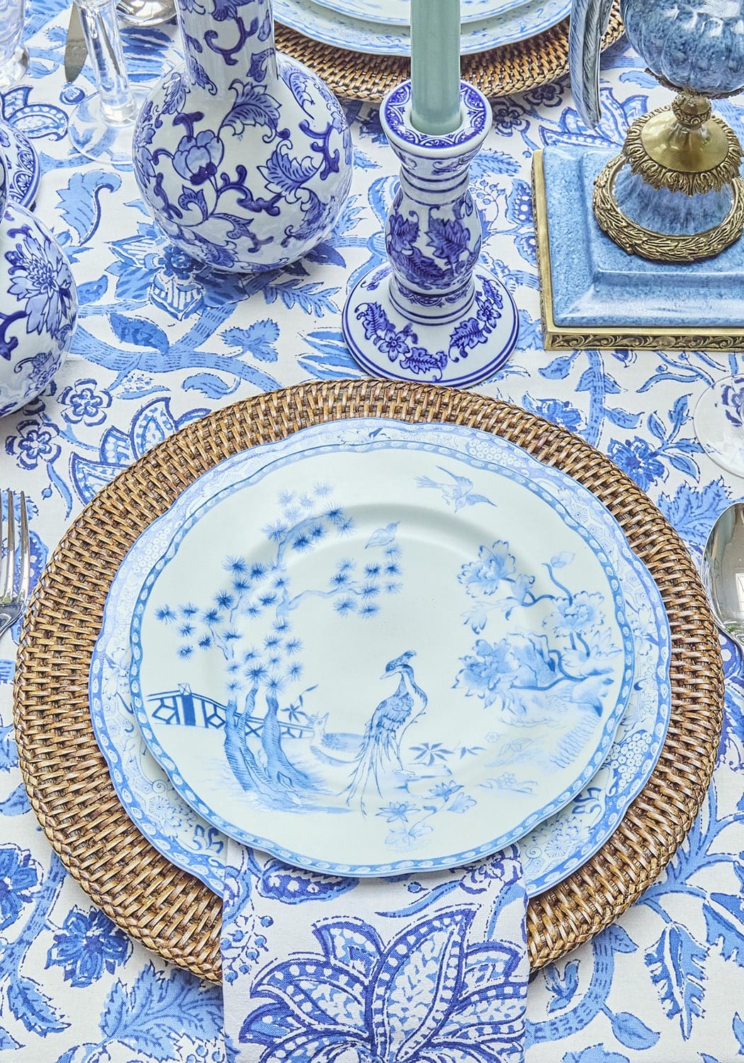 Blue and white porcelain dessert plate with delicate peacock design on woven wicker placemat set of 4