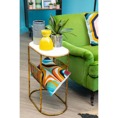 Gold metal side table with white marble top and colorful magazine rack featuring a visage small yellow face vase