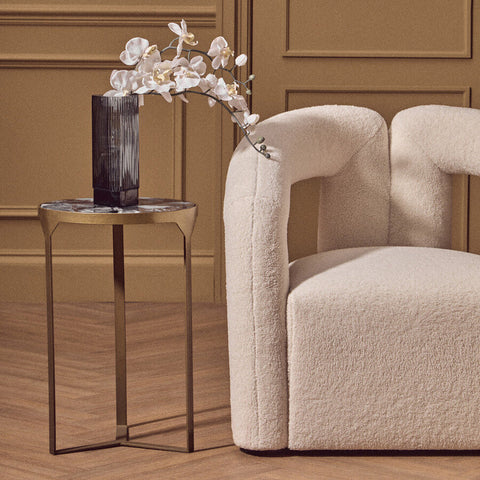 Cream-colored plush sheepskin armchair with rounded contours pairs perfectly with vizzini round agate side table