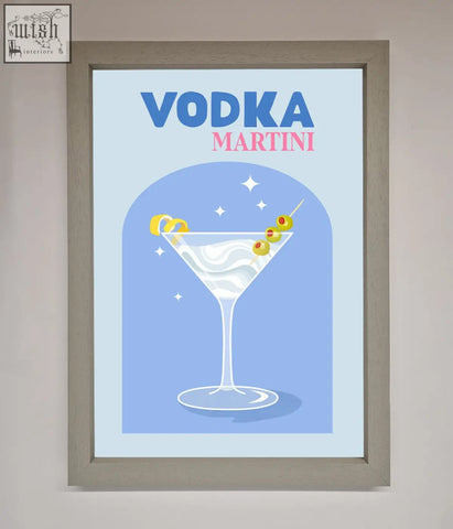 A vodka martini framed wall art featuring a classic martini glass with green olives and lemon twists on blue background