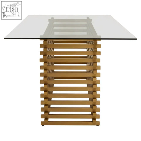 Modern matte gold dining table with clear glass top and stacked light oak wooden base for stylish dining rooms