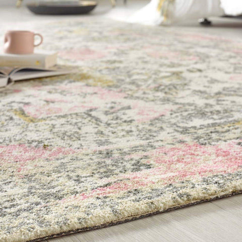 A soft plush vogue vintage pink rug with faded floral pastel pink and muted gray tones on an off-white background