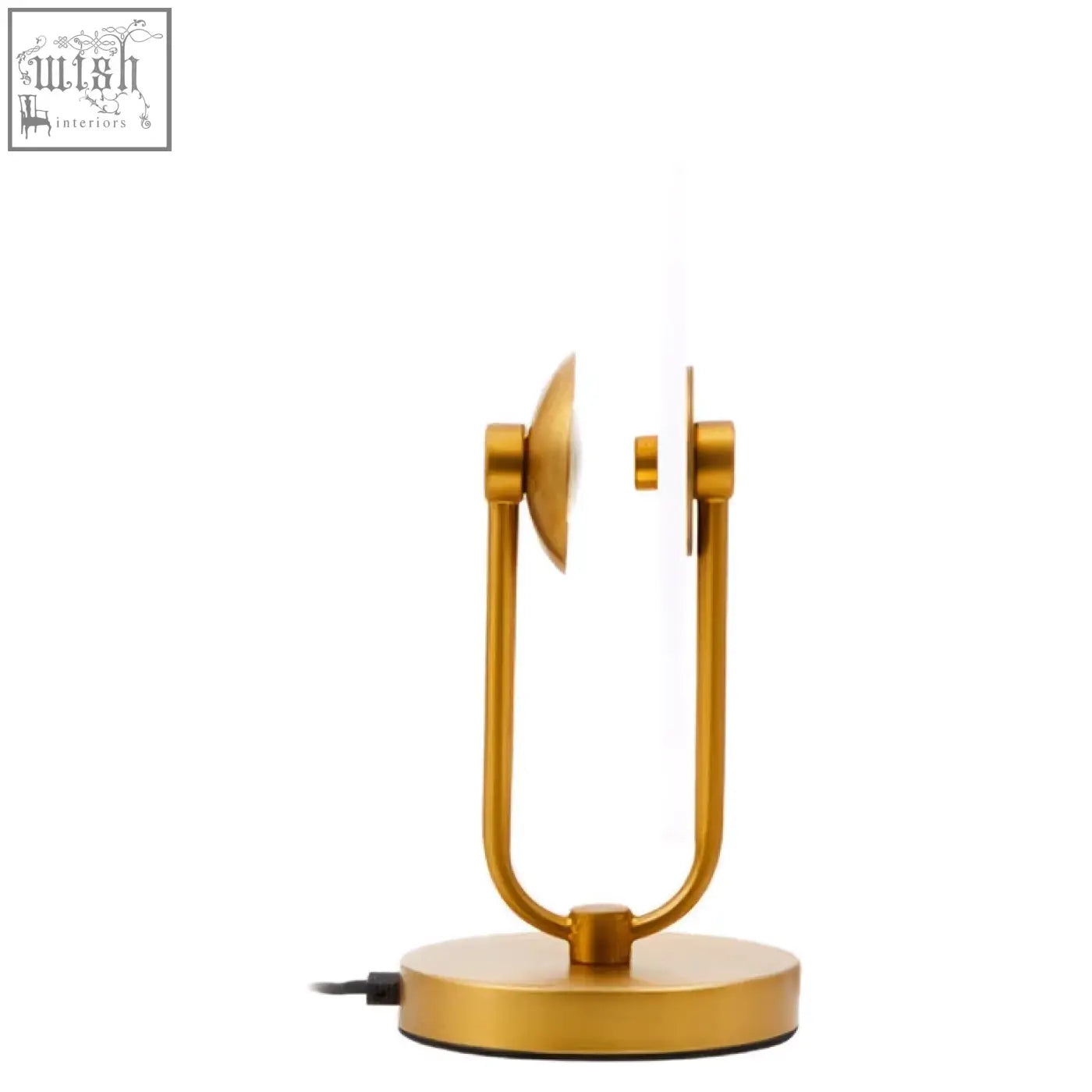 Gold-toned minimalist table lamp with curved metal arms and circular base on a white marble table lamp base