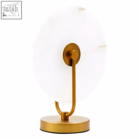Gold-toned vanity mirror with circular white marble table lamp face and sleek metal frame on marble table lamp