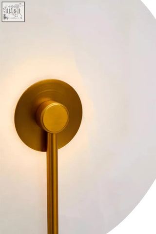 Gold-toned wall sconce with sleek cylindrical stem and circular mount for elegant white marble wall lighting