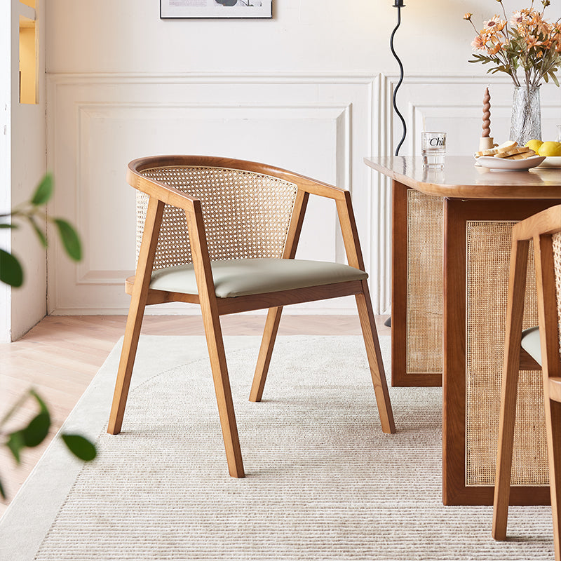 A wooden chair with woven cane back and light green cushion from the waldron rattan dining table set