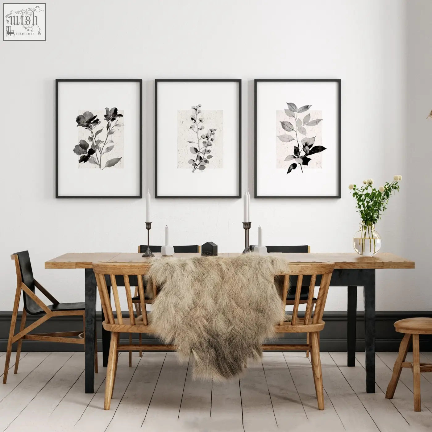 Three black-framed grey french country botanical wall art canvas prints above a wooden dining room table