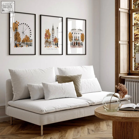 White upholstered sofa with metallic legs and cushions in living room featuring autumn day in london wall art decor prints