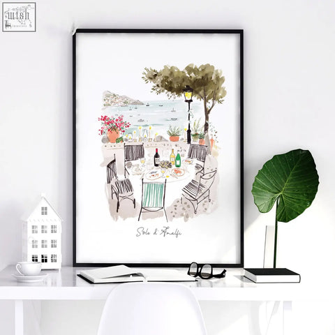 Black-framed watercolor wall art of seaside dining scene with greenery and wine bottles for dining room set of three prints