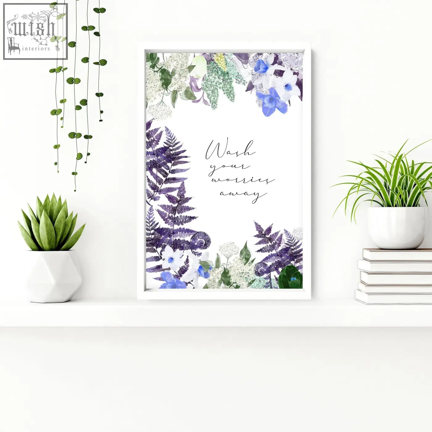 A framed watercolor wall art print with purple blue flowers green ferns and wash your worries away text for bathrooms