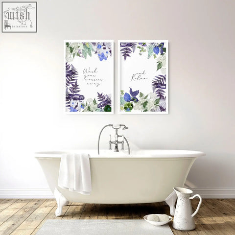 White clawfoot bathtub with silver faucet and white towel next to floral wall art prints for bathroom decor