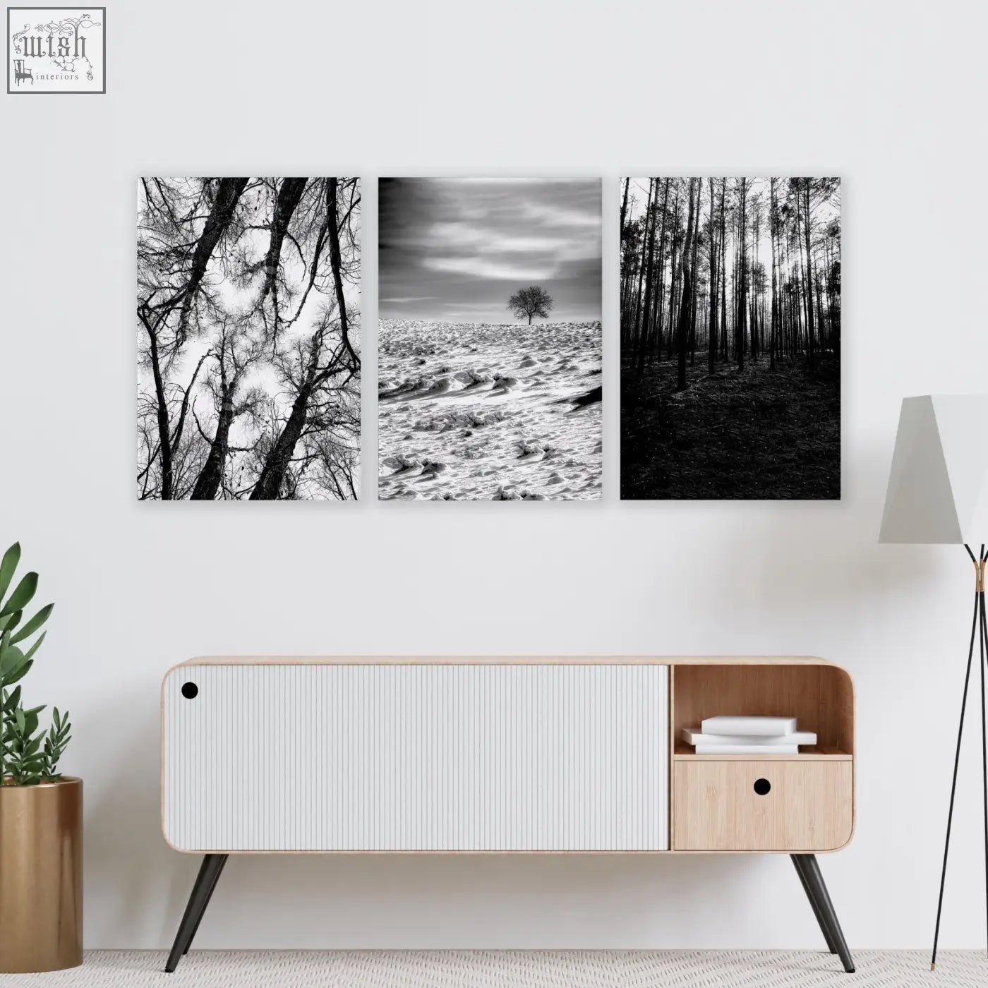 Minimalist white and light wood sideboard with black legs below black and white forest winter landscape wall art for grey walls living room