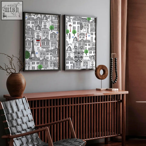 Two framed wall art paris cityscape illustrations with black and white line art and green trees on a gray wall