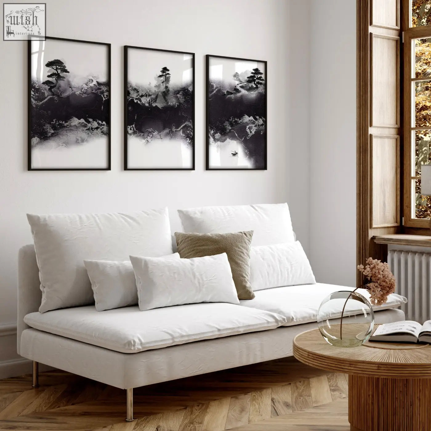 White upholstered sofa with metallic legs and cushions in a high ceiling living room with japandi art prints set of 3