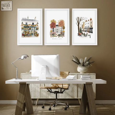 Three framed london travel art prints in watercolor hang above a white desk as wall decor office wall art