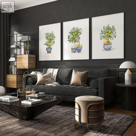 Dark gray upholstered sofa with plush cushions and beige brown white pillows near lemon tree living room art prints set