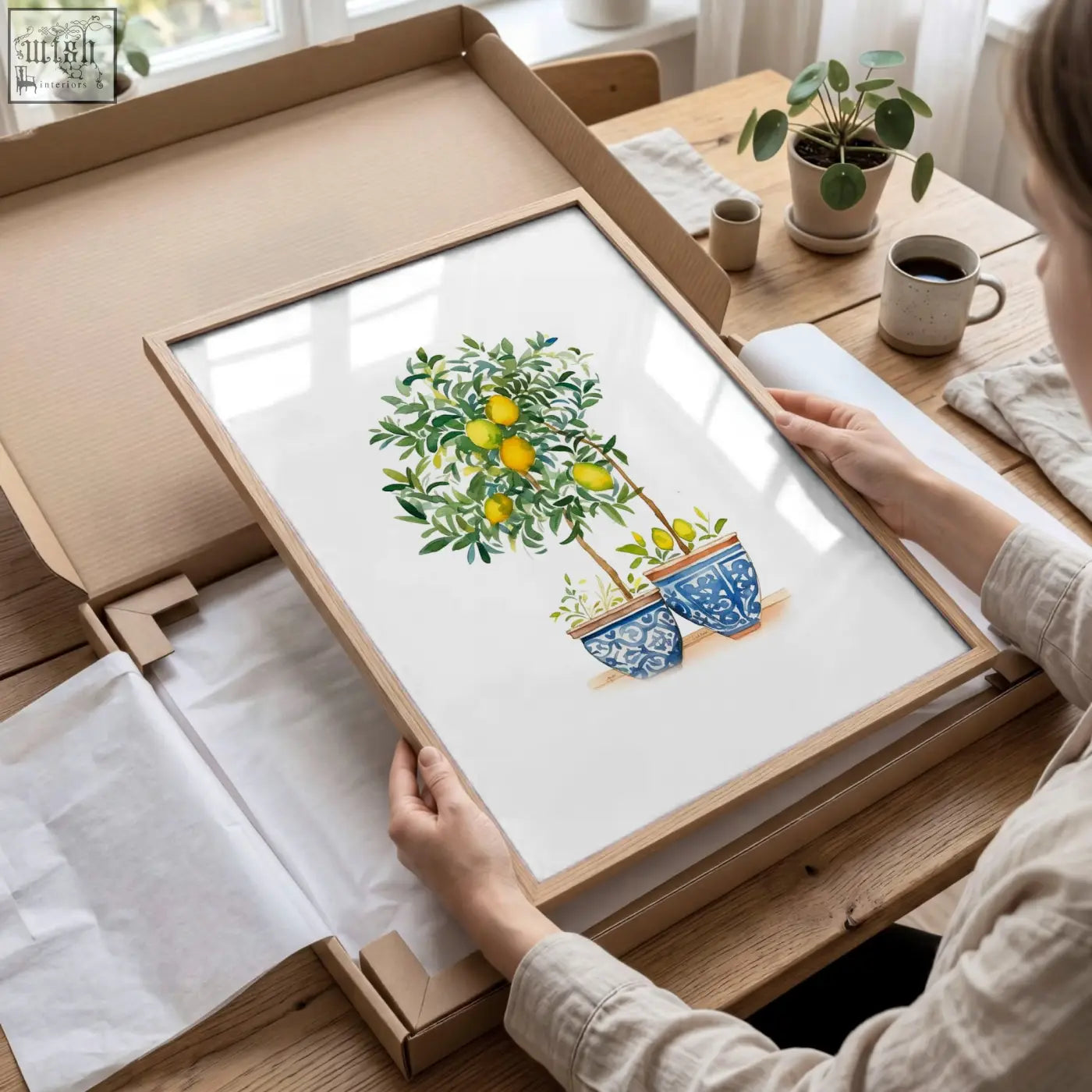 A framed lemon tree watercolor art print in blue and green tones with a light wood frame for living room wall decor