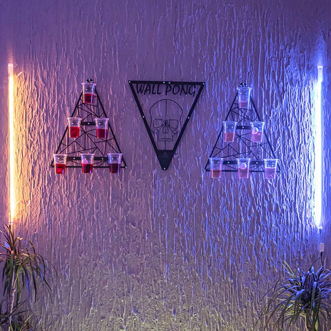 Black metal wall pong drinking game with skull design and triangular racks for opposing teams cups setup
