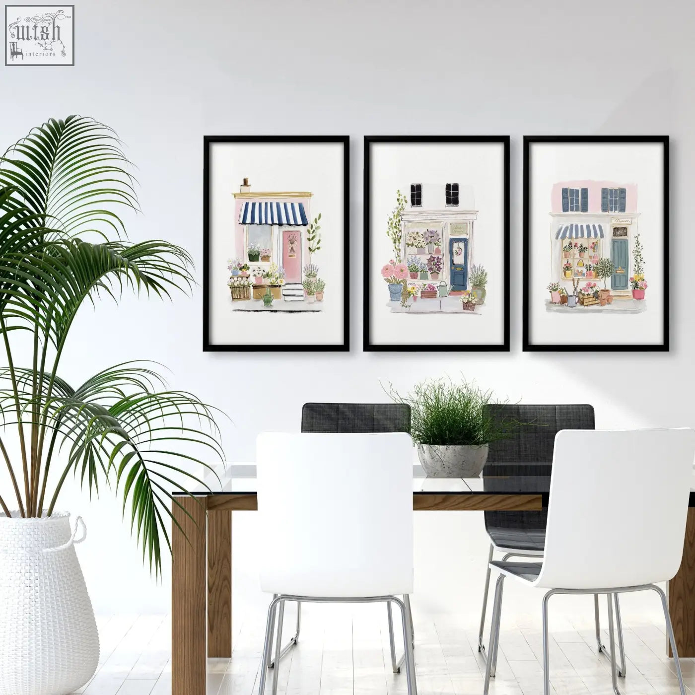 Three framed wall prints blue flower shop watercolor art hang above a dining room table in black frames