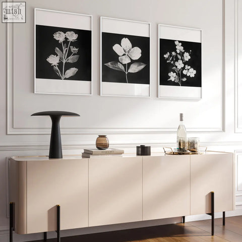 Beige minimalist sideboard with sleek flat-panel doors and black legs paired with white botanical french country wall prints