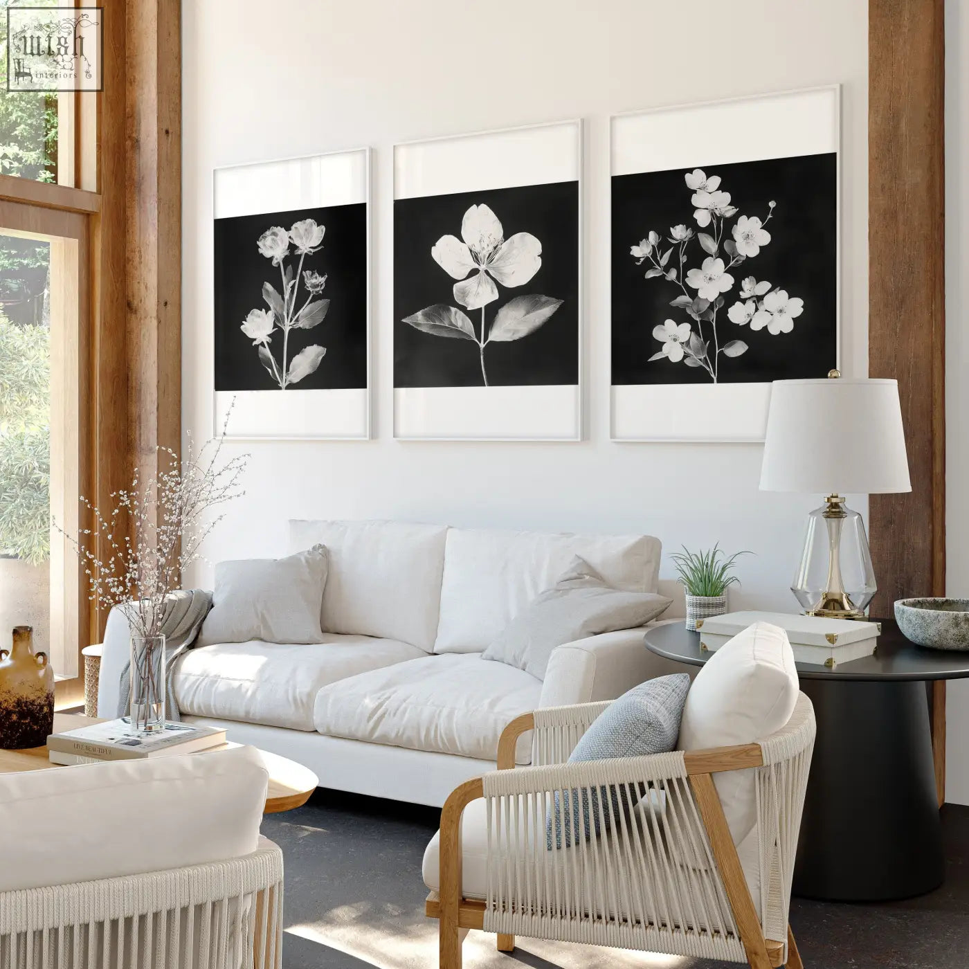 Three framed black and white botanical floral prints in french country style hang above white sofa in living room