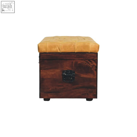 A tufted mustard-yellow leather top sits on a dark walnut storage trunk bench with a black metal handle and tan leather seat