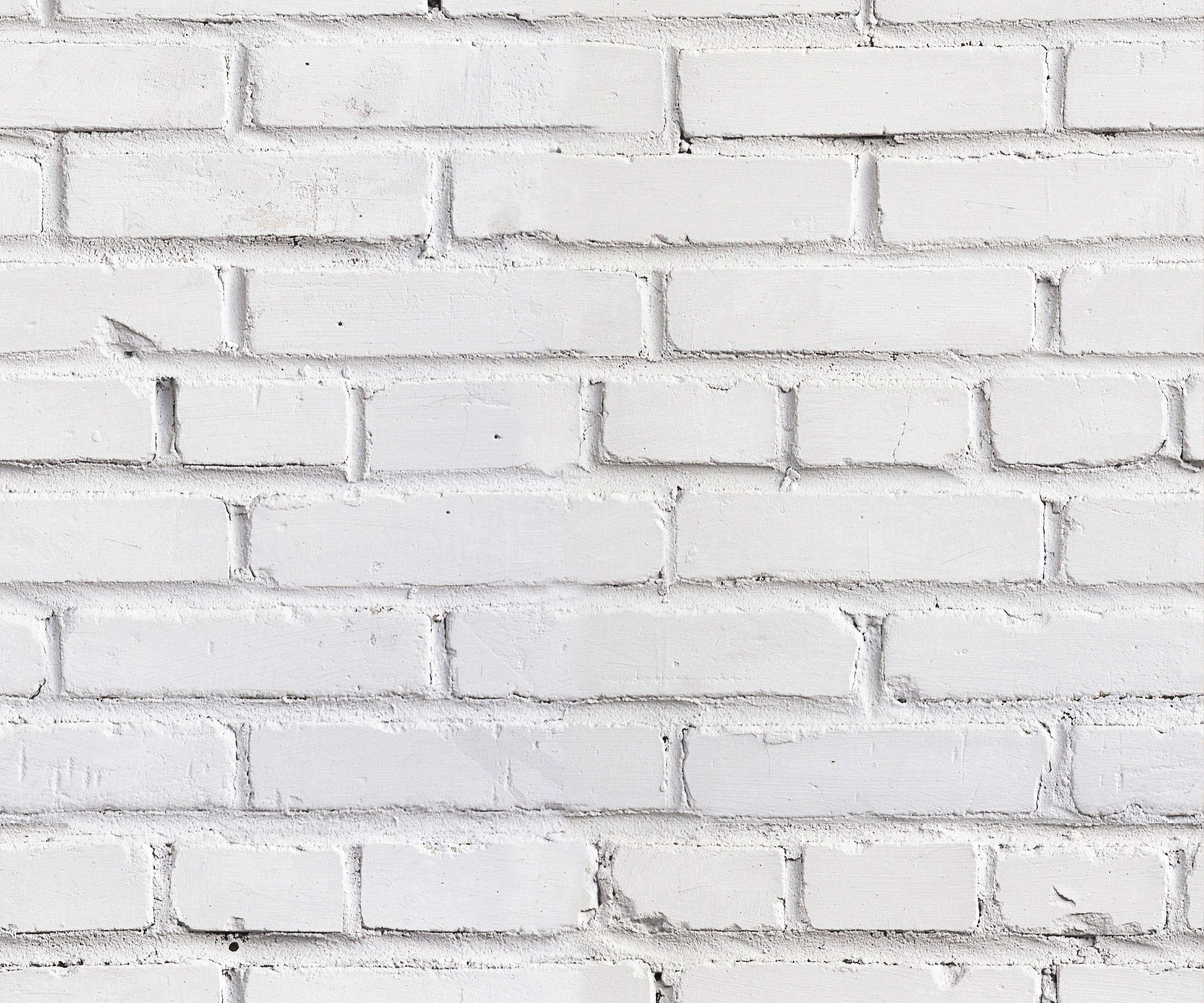 Warehouse white painted brick wall with visible mortar lines and subtle texture for industrial style decor