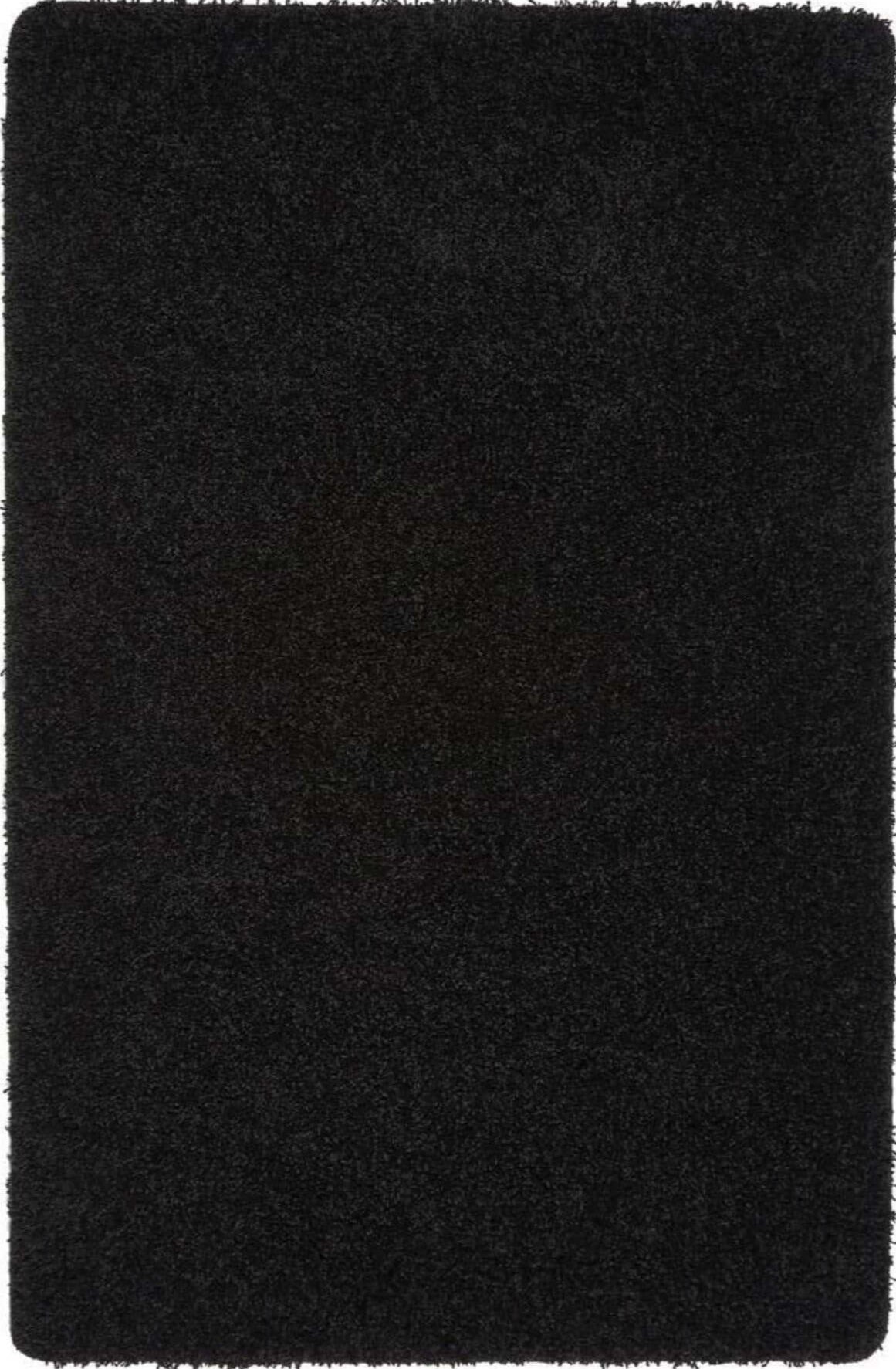 Black plush washable black shaggy rug with soft dense pile and slightly frayed edges for cozy spaces