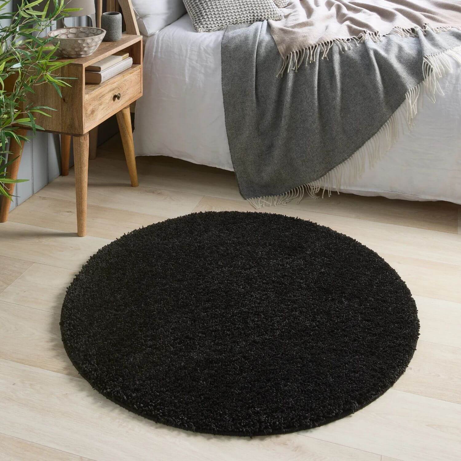 Black shaggy rug with washable black material featuring a soft circular design for easy cleaning and comfort