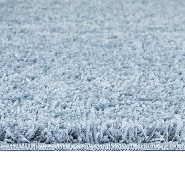 Light blue washable blue shaggy rug with plush textured surface and neatly finished edge for cozy spaces