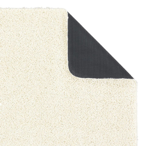 A washable ghost ivory shaggy rug with cream-colored plush texture and black non-slip backing shown from the back side