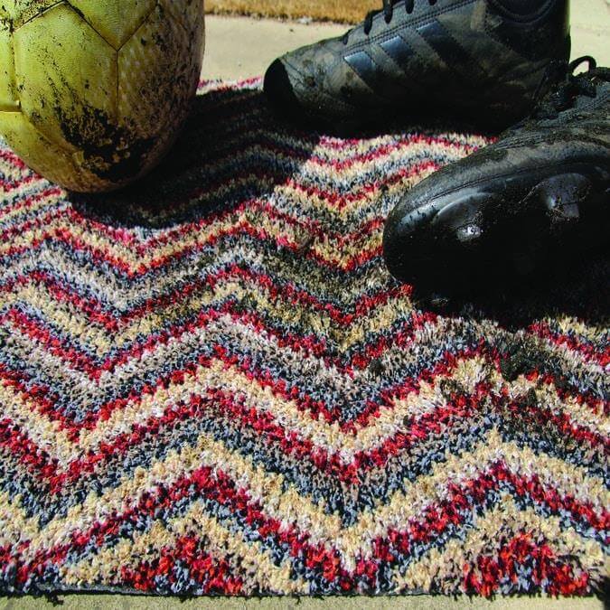 Colorful washable mat with chevron design in red black beige and gray textured stripes perfect for any room
