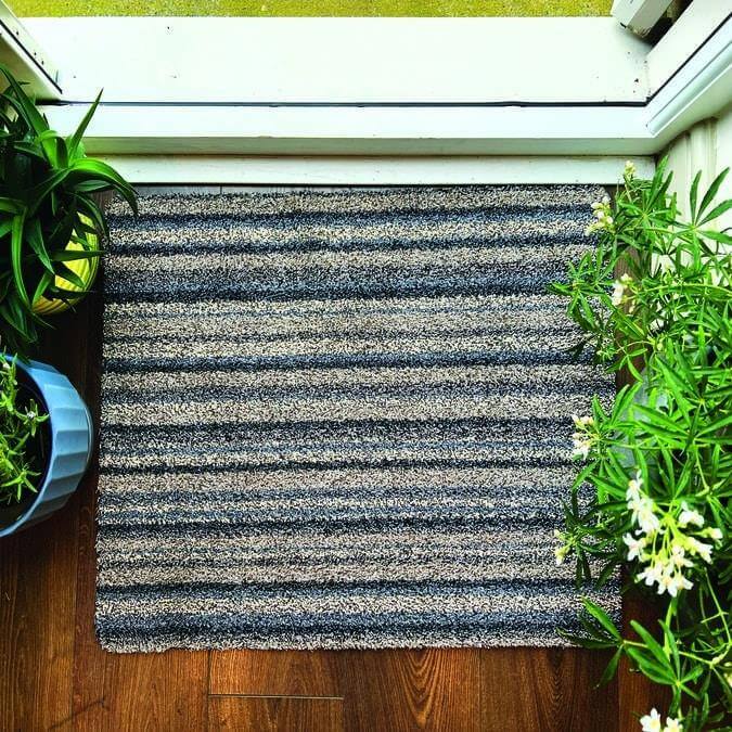 A rectangular washable ribbon mat with dark gray and beige striped fibers perfect for indoor use