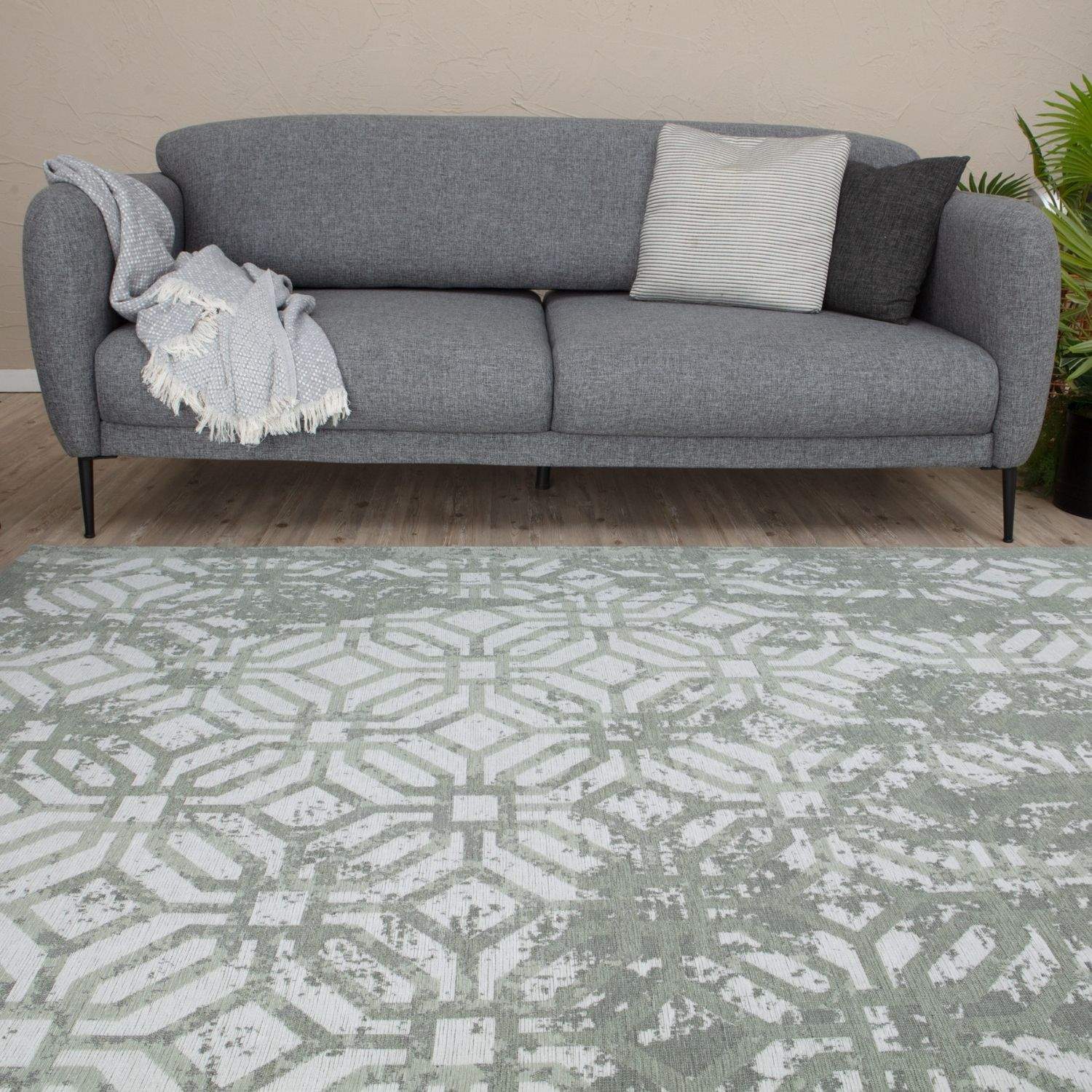 Gray textured sofa with black legs and decorative pillows shown with washable carina green rug for a cozy space