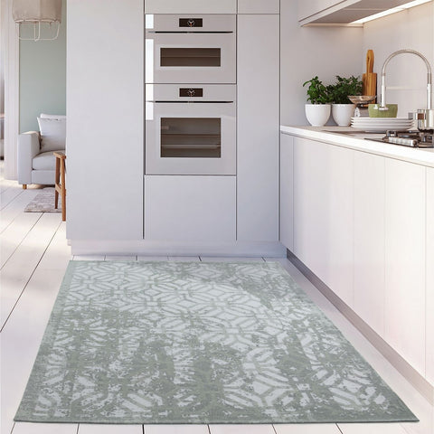 A washable carina green rug featuring a light green and white geometric pattern with a modern textured design