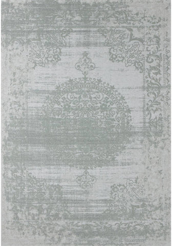 A vintage inspired washable rug carina green with a faded distressed pattern in muted sage green and off white tones