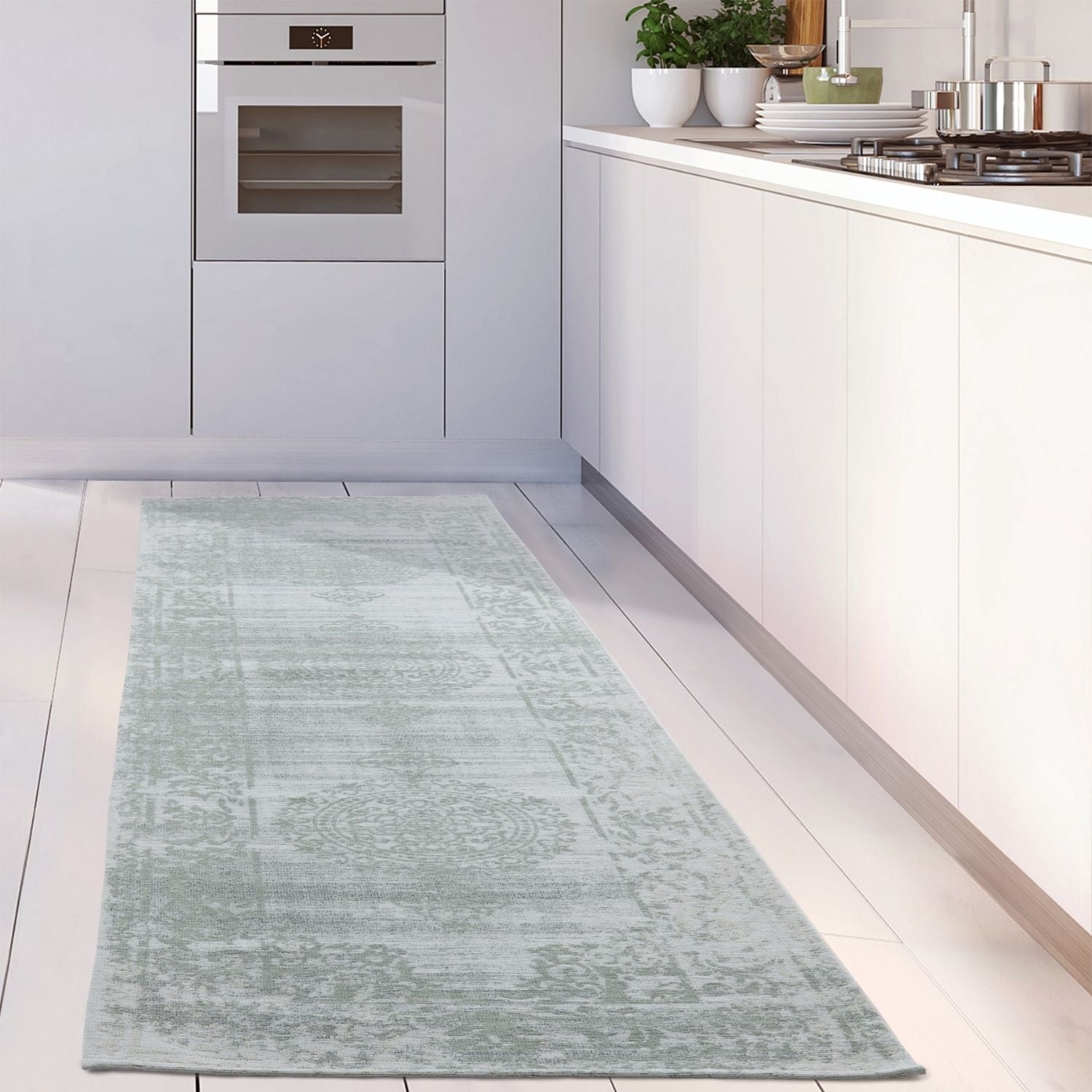 A light blue vintage style runner rug with faded floral pattern perfect as a washable carina green kitchen rug