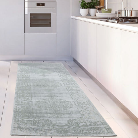 A light blue vintage style runner rug with faded floral pattern perfect as a washable carina green kitchen rug