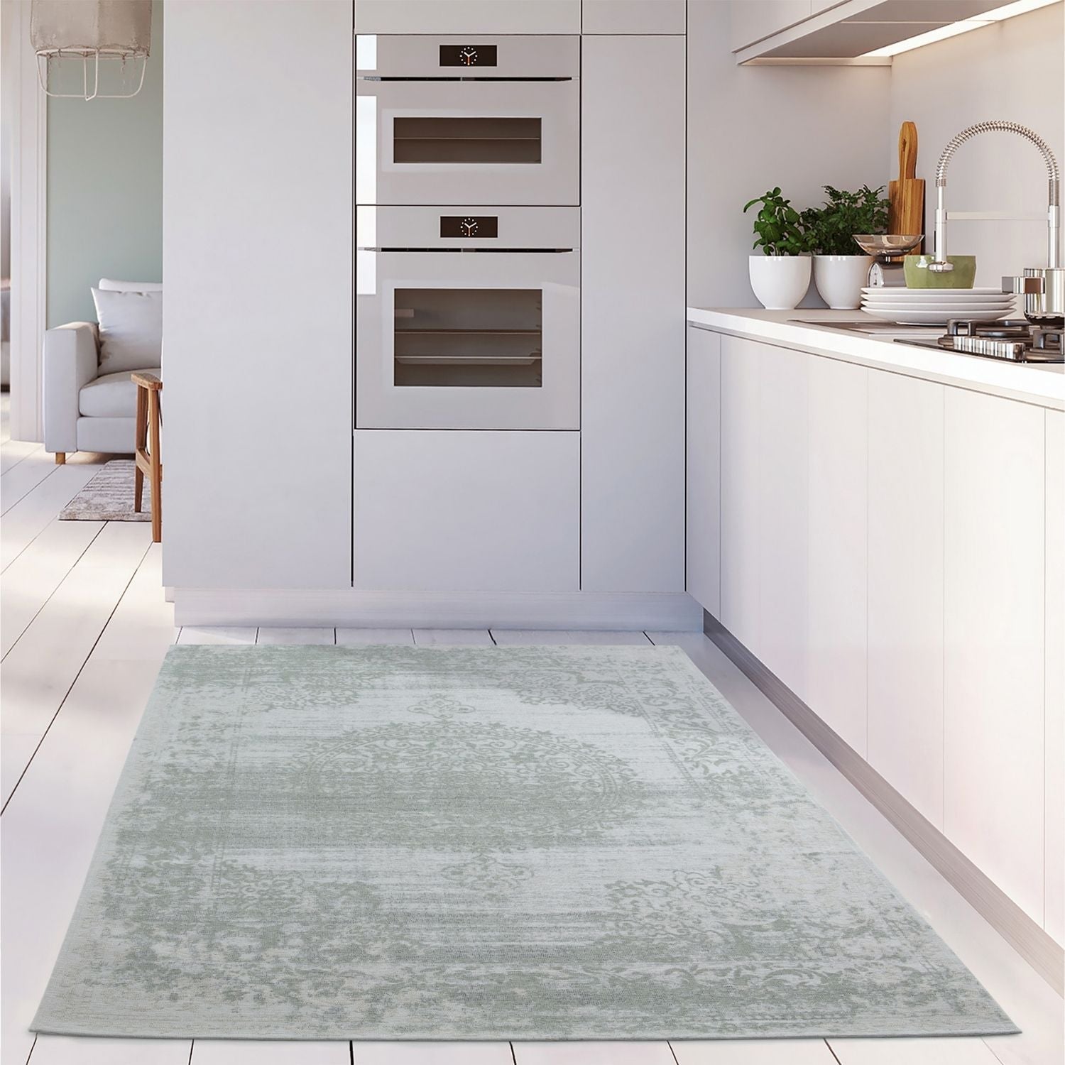 A soft washable rug carina green with a vintage floral pattern in light greenish blue and subtle distressing