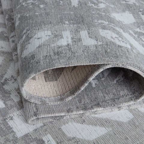 A washable rug carina grey with a textured grey rug geometric pattern and a woven slightly distressed finish