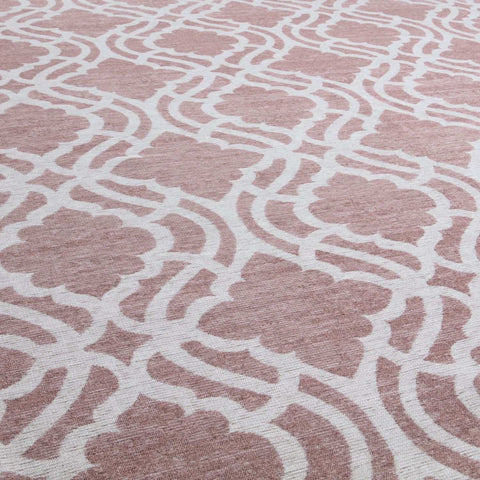 A soft pink washable rug carina with a repeating white geometric pattern perfect for easy cleaning and style