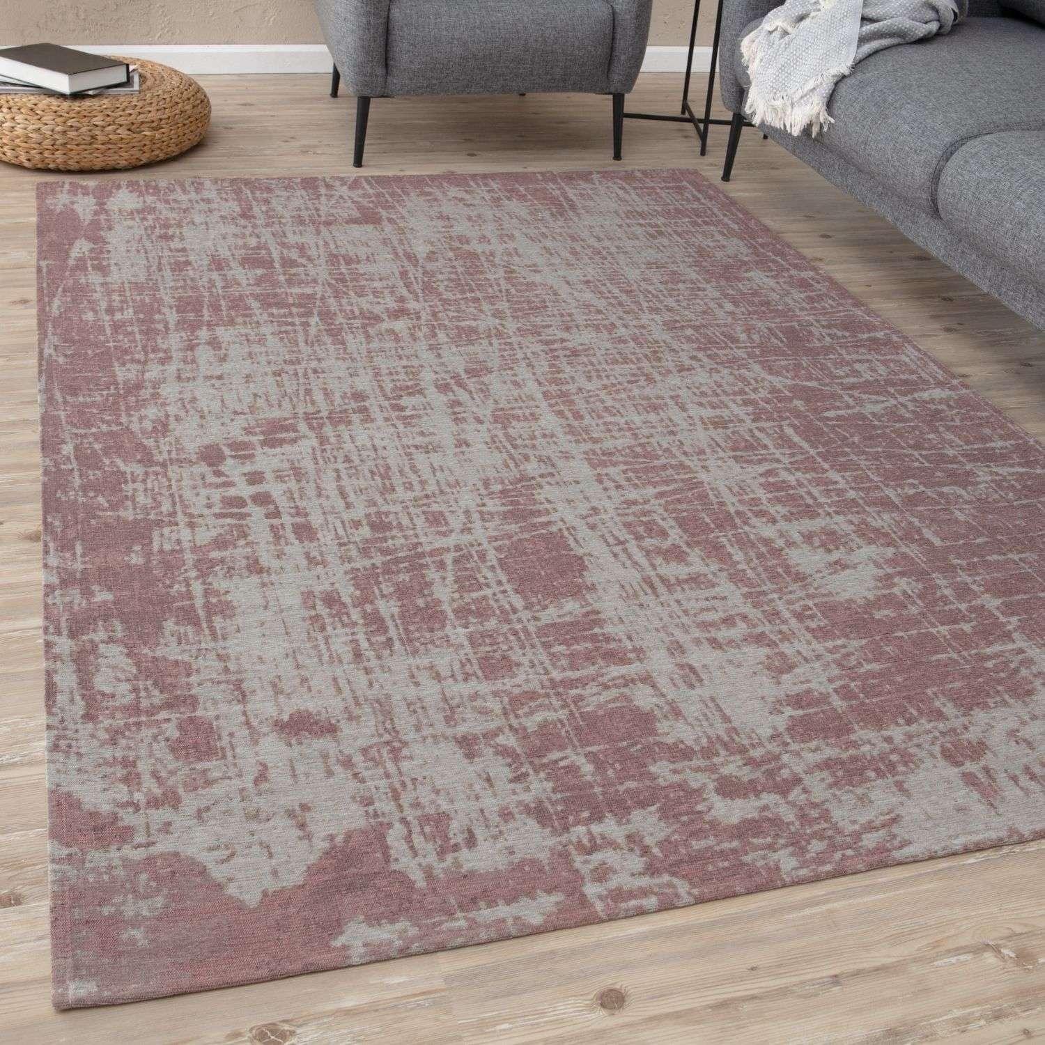A washable rug carina with a distressed abstract pattern in muted rose and gray tones perfect for any room