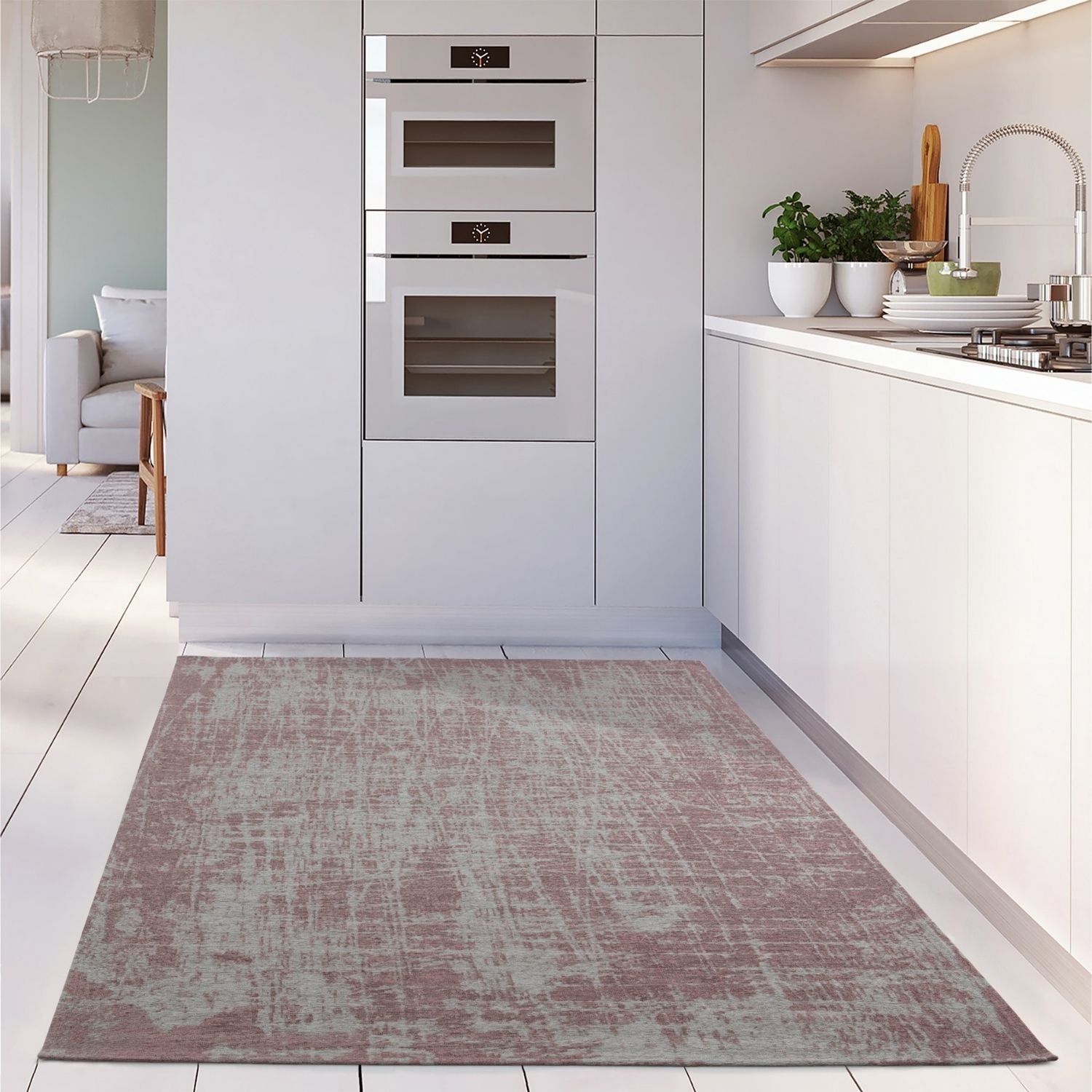 A rectangular distressed mauve and gray washable rug carina pink with vintage texture on a white wooden floor