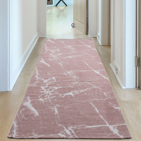 A soft pink washable rug carina with a white marble-like pattern perfect for easy cleaning and style