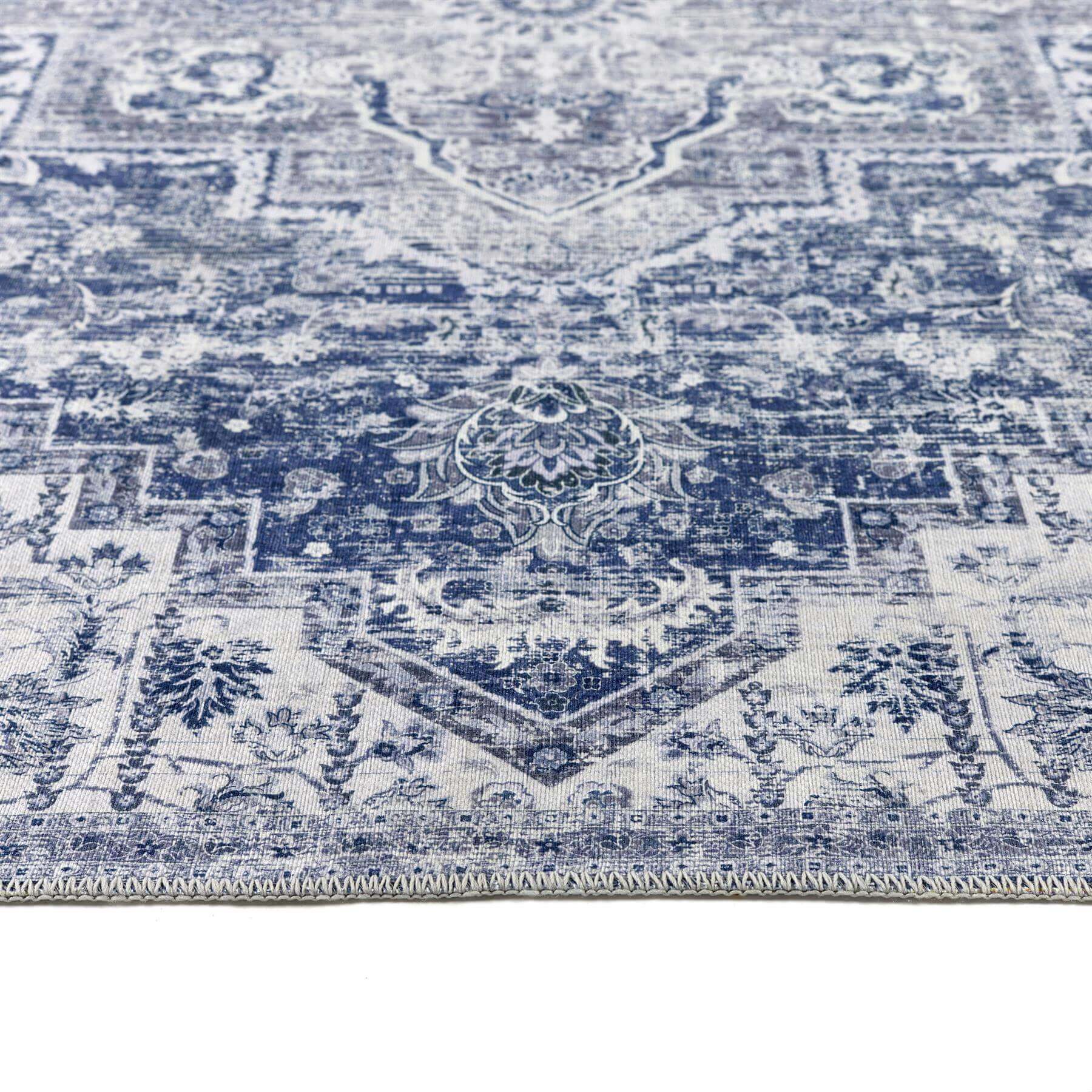 Vintage-inspired eterna blue washable rug with faded blue and cream floral and geometric patterns
