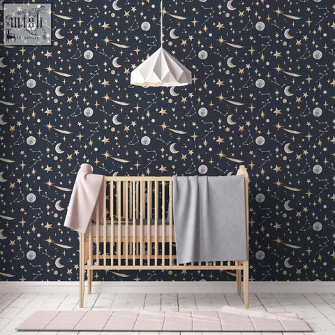 Lightweight wooden crib with soft pink and gray blankets in front of glowing stars constellation wallpaper night sky background