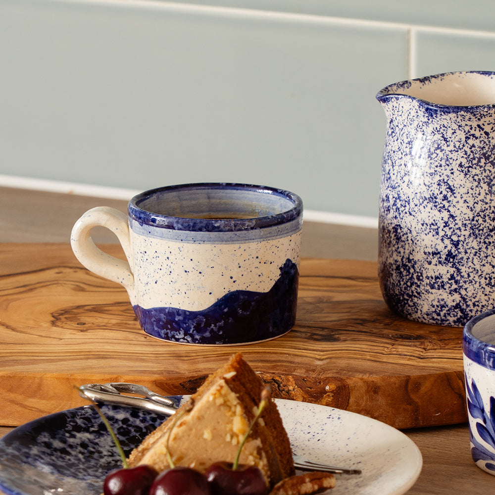 Wave ceramic espresso cup with hand painted dark blue wave design on speckled white and blue ceramic mug